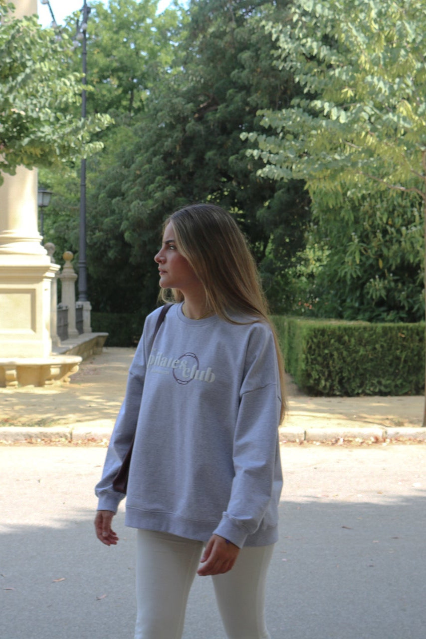 Mujer caminando por la ciudad con la sudadera Pilates Club oversized